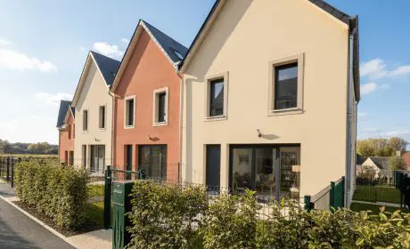 Maisons neuves du programme le Hamo à Pont-l’Évêque avec jardins et façades contemporaines.