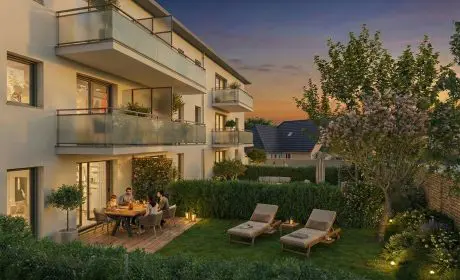 Le Clos de la Fonderie, résidence neuve à Louvigny avec jardin privatif et terrasses, propose des appartements modernes entourés d’espaces verts au coucher du soleil.