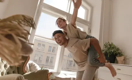 Couple heureux devant une fenêtre après la signature d'un appartement chez le notaire